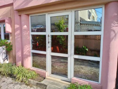 uma casa cor-de-rosa com uma grande porta de vidro em 1-bedroom apartment in dolphin em Lagos