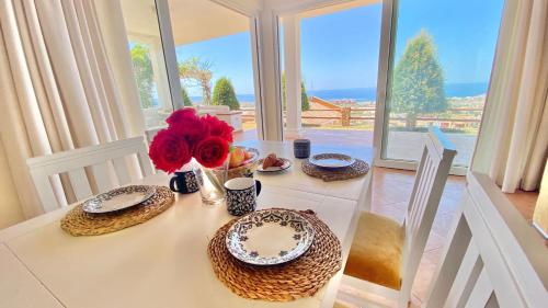 a dining room table with plates and flowers on it at Villa Fabiola at Home in Málaga