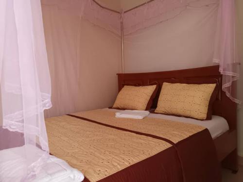 a bedroom with a bed with a canopy at City Cottages Mbale in Mbale