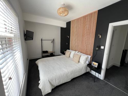 1 dormitorio con cama blanca y pared negra en Modern 2 bedroom beach house en Cleethorpes