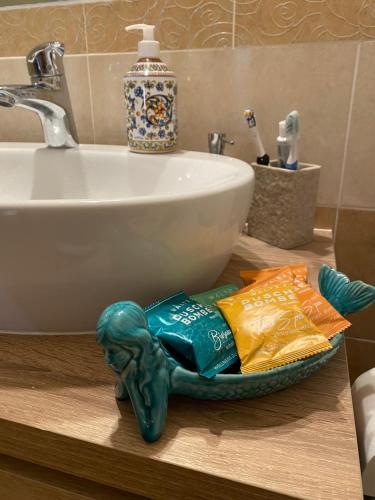 a bathroom counter with a sink and a pile of toiletries at La Collina sul Mare - Casa Vacanze in Sestri Levante
