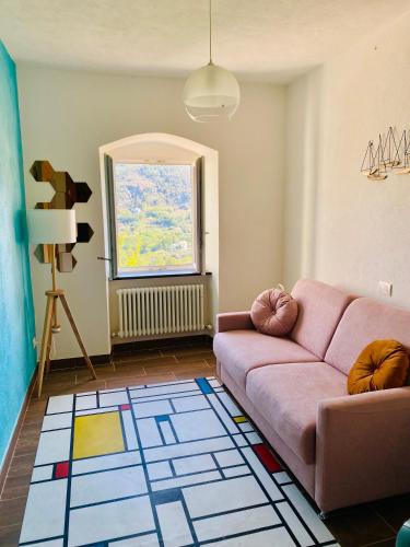 a living room with a pink couch and a window at La Collina sul Mare - Casa Vacanze in Sestri Levante
