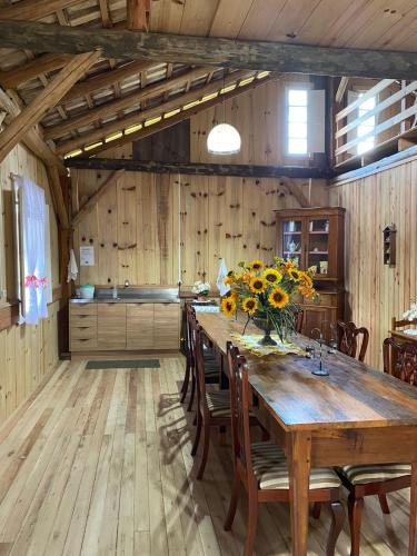 a kitchen with a wooden table with flowers on it at Casarão Biazolli in Farroupilha
