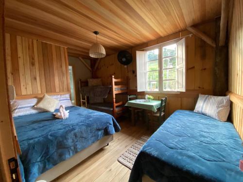sypialnia z 2 łóżkami w drewnianym domu w obiekcie Casarão Biazolli w mieście Farroupilha
