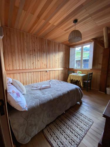 a bedroom with a bed in a room with a table at Casarão Biazolli in Farroupilha