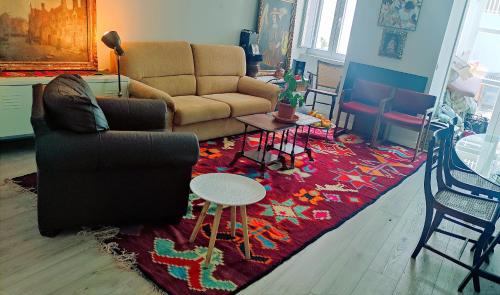 a living room with a couch and a rug at Parede beach in Almada