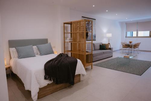 a bedroom with a bed and a living room at Las Canteras Beach Suites in Las Palmas de Gran Canaria