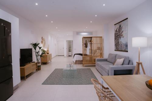ein Wohnzimmer mit einem Sofa und einem Tisch in der Unterkunft Las Canteras Beach Suites in Las Palmas de Gran Canaria