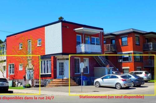 un bâtiment rouge avec des voitures garées devant lui dans l'établissement WOW - Loft Vieux-Limoilou à proximité Vieux-QC!, à Québec