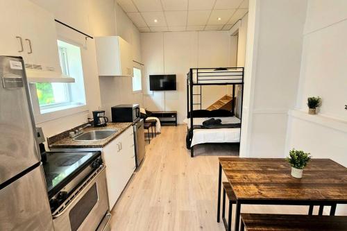 Il comprend une petite cuisine avec une table et des lits superposés. dans l'établissement WOW - Loft Vieux-Limoilou à proximité Vieux-QC!, à Québec
