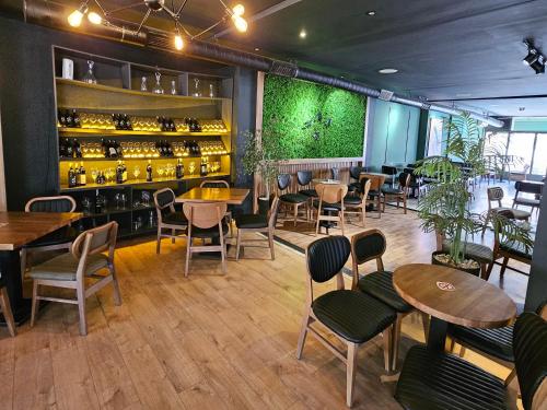 ein Restaurant mit Tischen und Stühlen und einer grünen Wand in der Unterkunft Green Apartments Prishtina in Pristina
