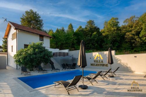 a villa with a swimming pool with chairs and umbrellas at Villa Milestone Majevica 