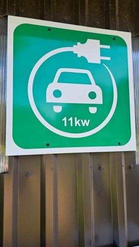 un cartello verde con un'auto in cerchio di Burziņi a Kuldīga