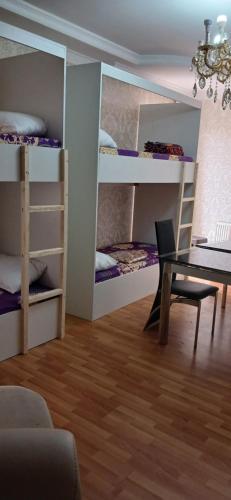 a room with bunk beds with a table and a desk at Central Baku Hostel in Baku