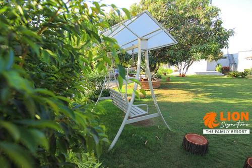 a swing in the grass in a yard at Lion Signature Family Resort in Sasan Gir