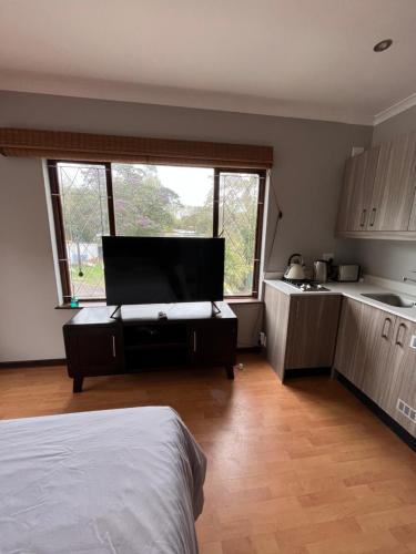 a bedroom with a bed and a kitchen with a window at The Three Trees in Gillitts