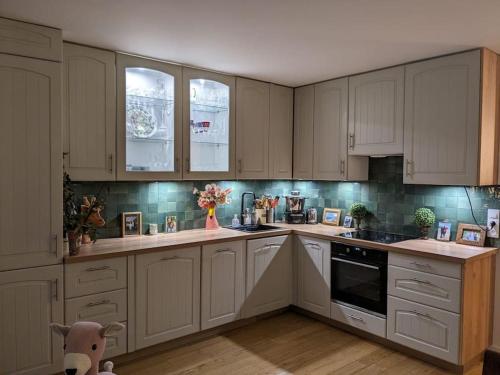 une cuisine avec des armoires blanches et un ours en peluche dans l'établissement Appartement avec balcon proche de Montmartre, à Paris