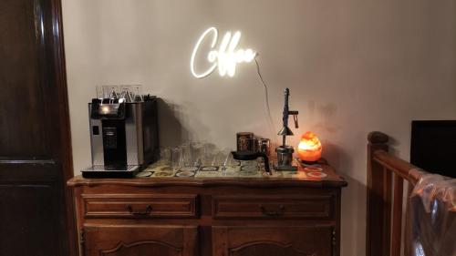 a table with a coffee maker and glasses on it at La Fontaine du Mas in Thiviers
