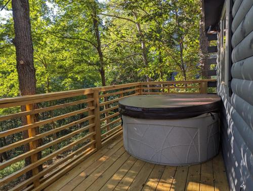 尤里卡斯普林斯Cabin #6 with hot tub deck and sunset view at Loblolly Pines的一个大垃圾桶可以坐在甲板上