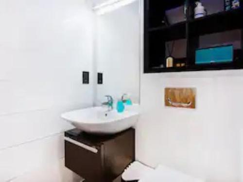 uma casa de banho com um lavatório branco e um espelho. em Pass the Keys Boutique London Flat near Tower Bridge and Tube em Londres