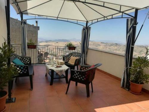 einen Balkon mit einem Tisch, Stühlen und einem Sonnenschirm in der Unterkunft B&B Al Borgo in Troina