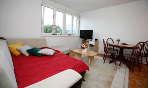 uma sala de estar com uma cama e uma mesa com cadeiras em Apartman CENTAR em Zenica