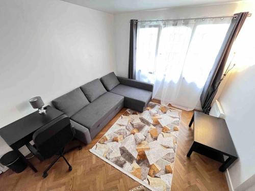 a living room with a couch and a large window at 2 pieces - Calme et Lumineux - Parc de La Villette - Stade de France in Aubervilliers