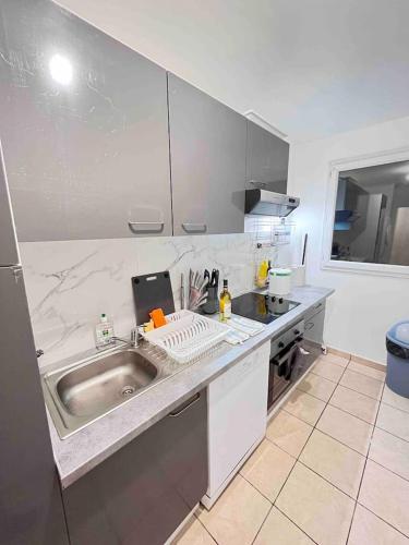 une cuisine avec un évier et un plan de travail dans l'établissement 2 pieces - Calme et Lumineux - Parc de La Villette - Stade de France, à Aubervilliers