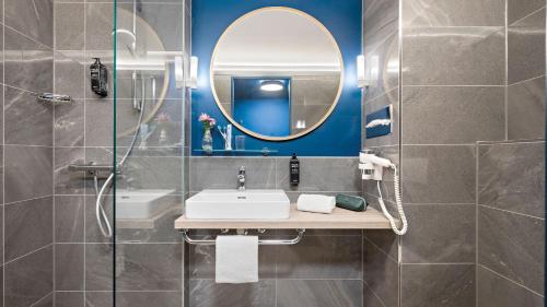 a bathroom with a sink and a mirror at Hey Lou Hotel Nördlingen in Nördlingen