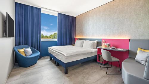 a bedroom with a bed and a desk and a chair at Hey Lou Hotel Nördlingen in Nördlingen
