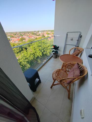 a balcony with a table and chairs and a view at Krstić_lux apartman in Subotica