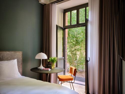 um quarto com uma cama, uma mesa e uma janela em sly Berlin em Berlim