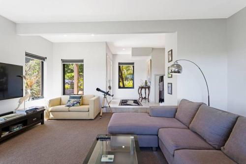 a living room with a couch and a table at Coastal meets Country at this Ventnor Beach Escape in Ventnor
