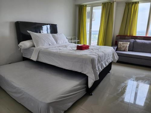 a bedroom with a large bed and a couch at Elegance Orchard in Surabaya
