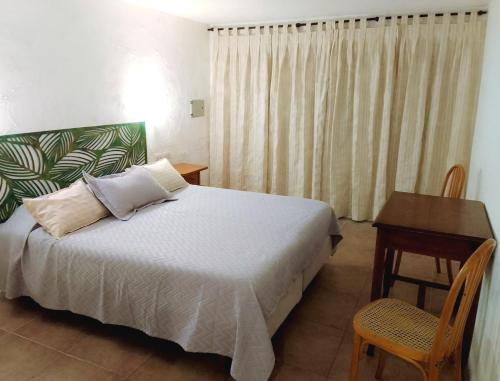 Hotel Medina B&B في مار ديل بلاتا: غرفة نوم بسرير وطاولة ومكتب