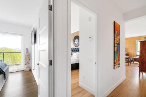 a room with white walls and a bedroom with a bed at Spacieux condo 3CH à proximité du Vieux-Québec WoW! in Quebec City