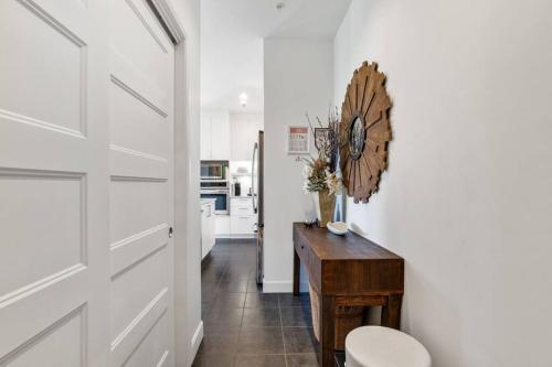 a white kitchen with a clock on the wall at Spacieux condo 3CH à proximité du Vieux-Québec WoW! in Quebec City
