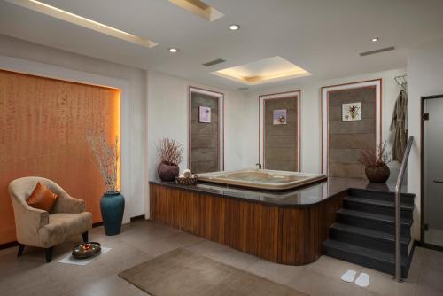 a bathroom with a tub and a chair and stairs at Radisson Blu Resort, Goa in Cavelossim