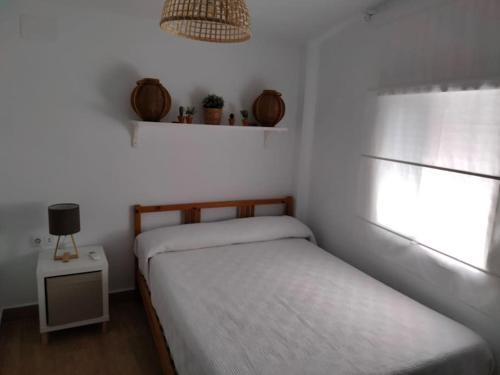 a small bedroom with two beds and a window at CASITA PINYPON in Jerez de la Frontera