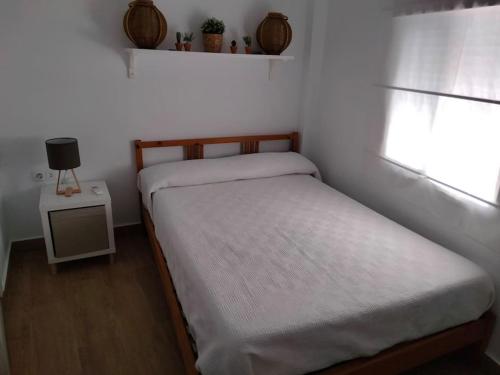 a small bedroom with a bed and a window at CASITA PINYPON in Jerez de la Frontera