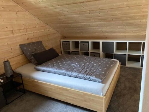 a bed in a cabin with a wooden ceiling at Ferienhaus Vogelnest in Marktschorgast