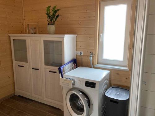 a laundry room with a washing machine and a window at Ferienhaus Vogelnest in Marktschorgast