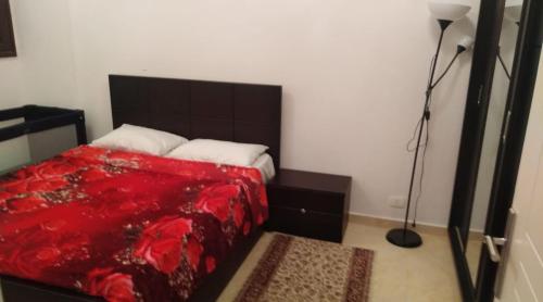 una camera da letto con un letto con una coperta rossa e una lampada di Turtles Beach resort a Hurghada