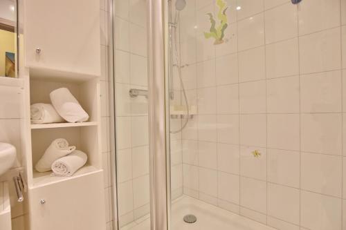 La salle de bains est pourvue d'une douche avec une porte en verre. dans l'établissement Parkresidenz Parkresidenz Appartement 2, à Scharbeutz