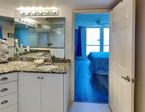 a bathroom with a sink and a mirror and a bed at Lovers Key Resort 1105 - 1 Bedroom - Sleeps 4 in Fort Myers Beach