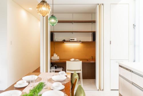 cocina y comedor con mesa y sillas en Comfort Villa YAGAJI en Nago