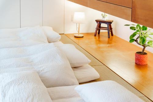 a living room with white furniture and a potted plant at Comfort Villa YAGAJI in Nago