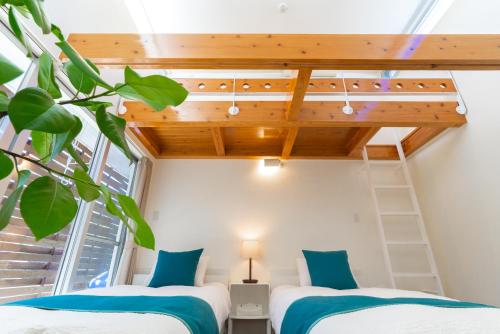 Duas camas num quarto com um loft em Comfort Villa YAGAJI em Nago