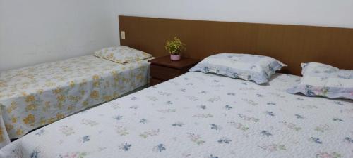 two beds sitting next to each other in a bedroom at Apto Completo - Vila do Mar - Beach Park - PDD in Aquiraz