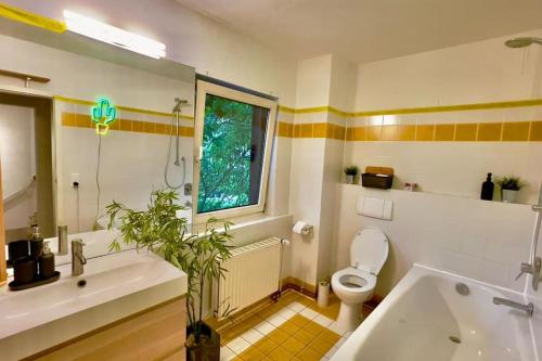 a bathroom with a tub and a toilet and a window at Unterkunft für Familien und Gruppen in Seenähe mit Garten in Hannover